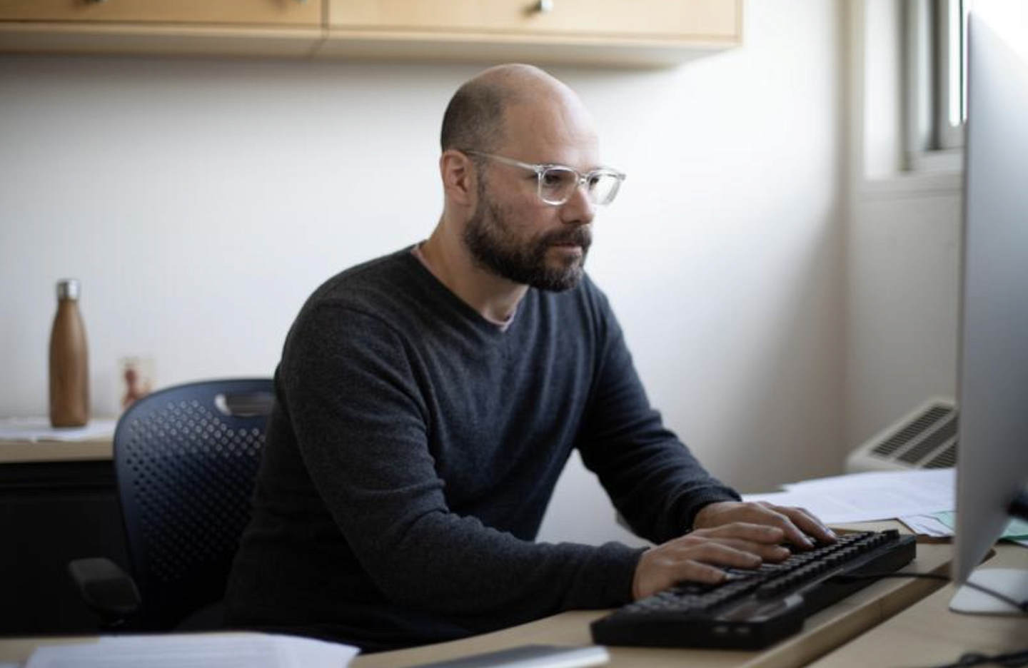 Faculty member Andrew Kern types on his computer