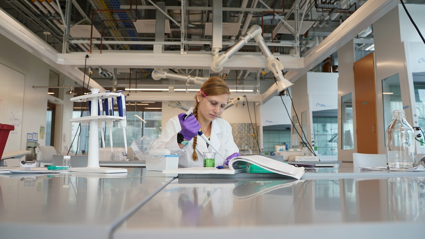Researcher in Knight Campus using a syringe