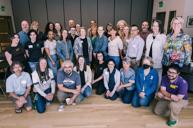 approximately 30 participants in 3 rows facing camera