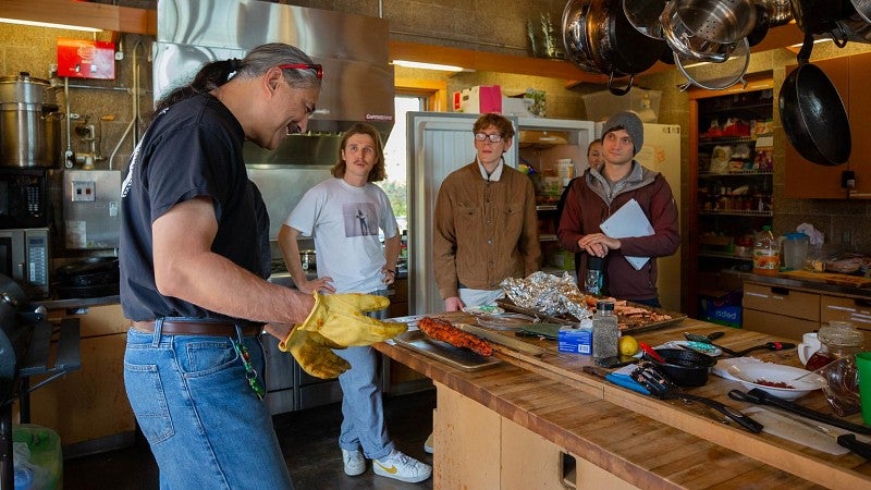 Faculty teaching longhouse salmon cooking