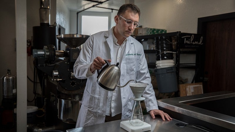 Chris Hendon pouring coffee in a lab