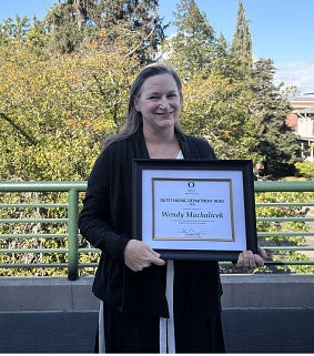 Wendy Machalicek holds framed certificate