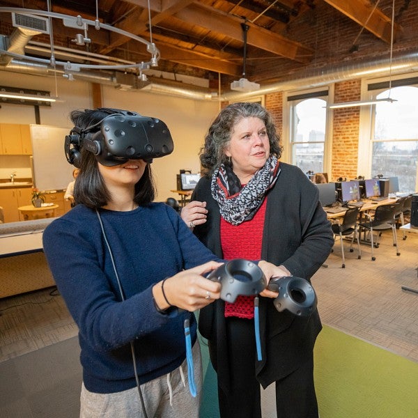 faculty member works with student in VR lab